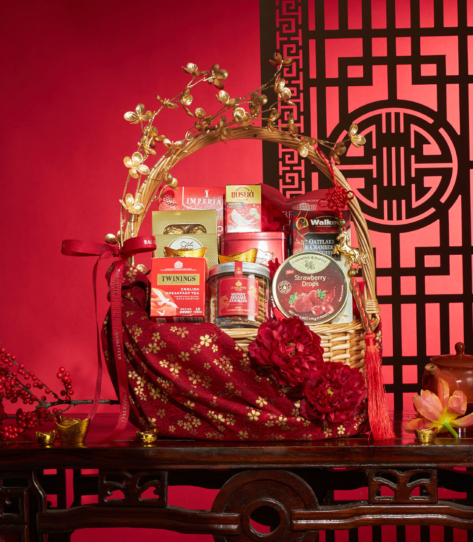 Golden wicker gift basket with gourmet treats, golden horse charm, and red tassel for Chinese New Year