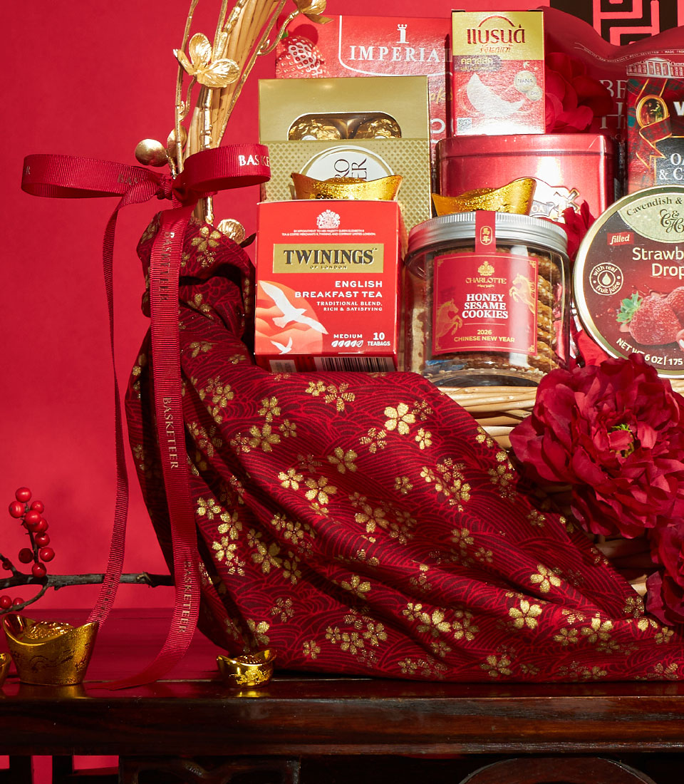Luxury red and gold Chinese New Year gourmet gift basket with tea, honey sesame cookies, chocolates, and festive gold accents