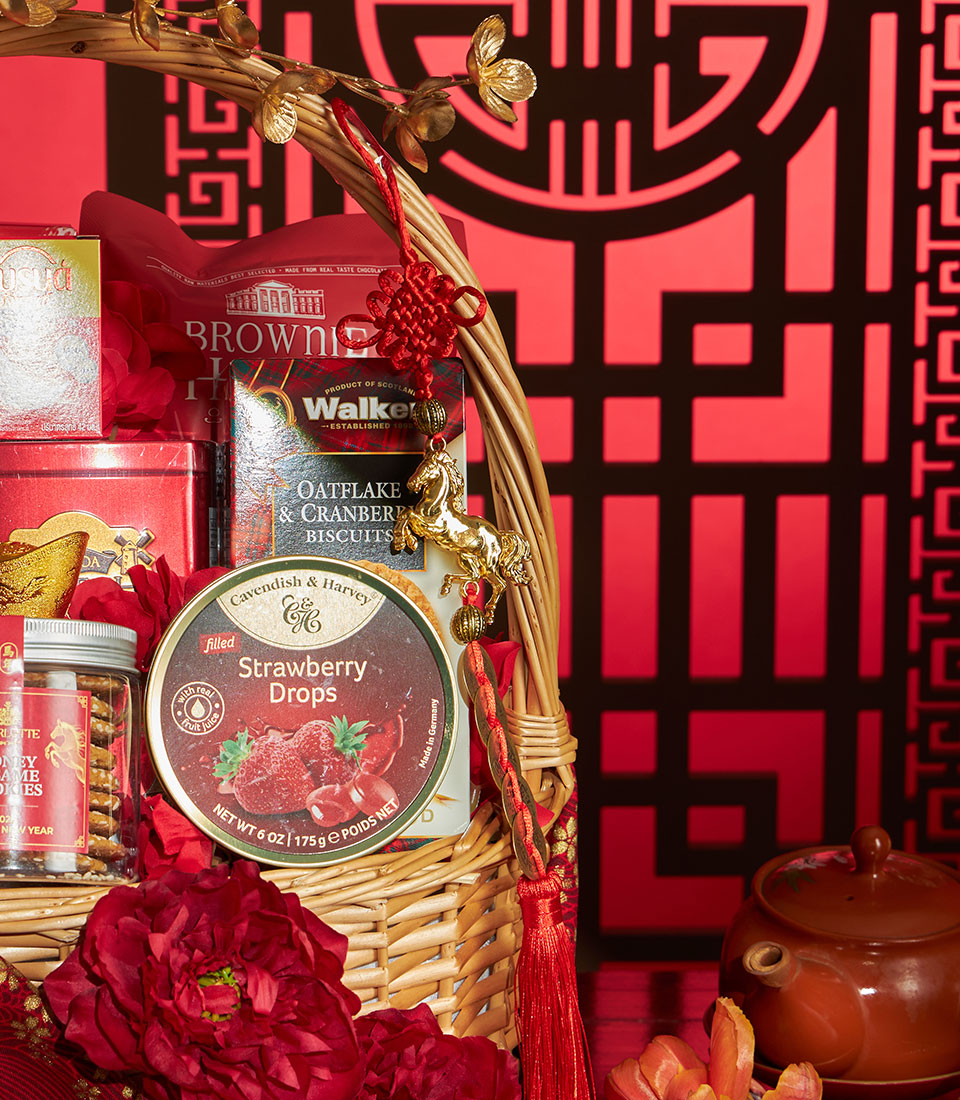 Golden woven gift basket with gourmet treats, red flowers, and gold horse charm for Chinese New Year