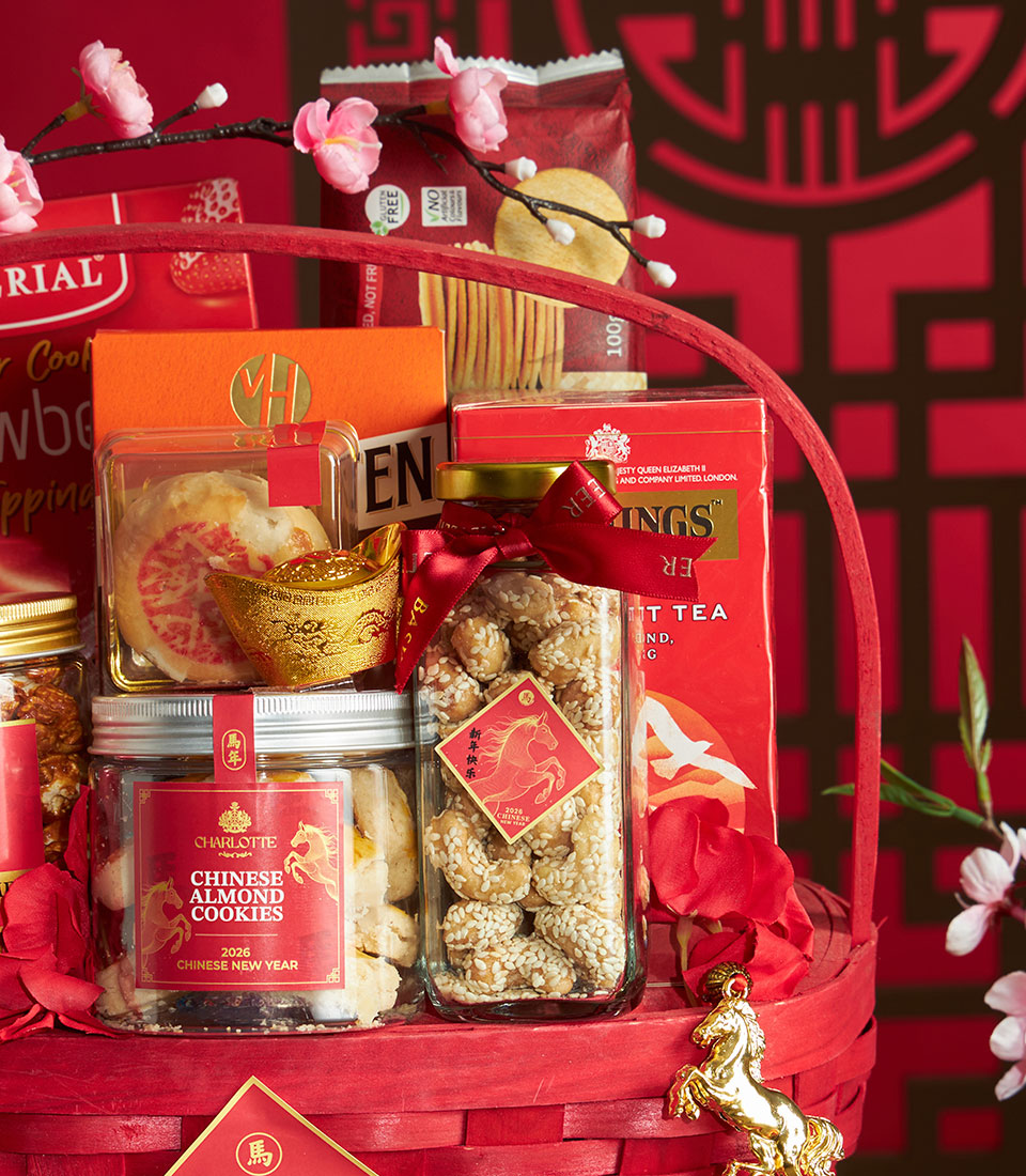 Vibrant red gift basket filled with Chinese New Year gourmet treats, almond cookies, sesame nuts, premium tea, and golden