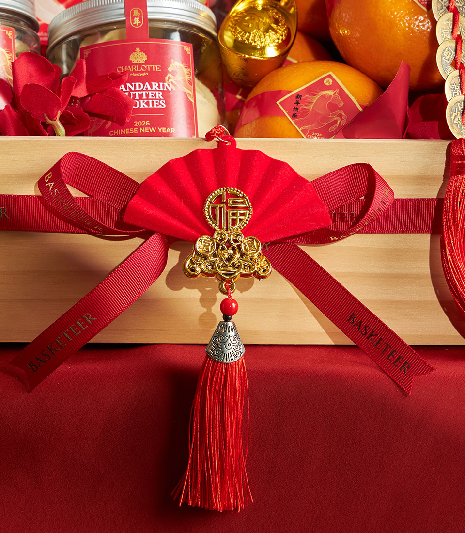 Luxury Chinese New Year gift basket with mandarin oranges, gourmet cookies, and gold prosperity accents in wooden box with