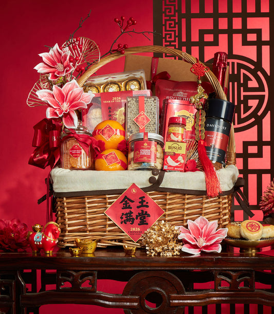 Woven wicker Chinese New Year gift basket with gourmet treats, fresh oranges, chocolates, coffee, and festive red