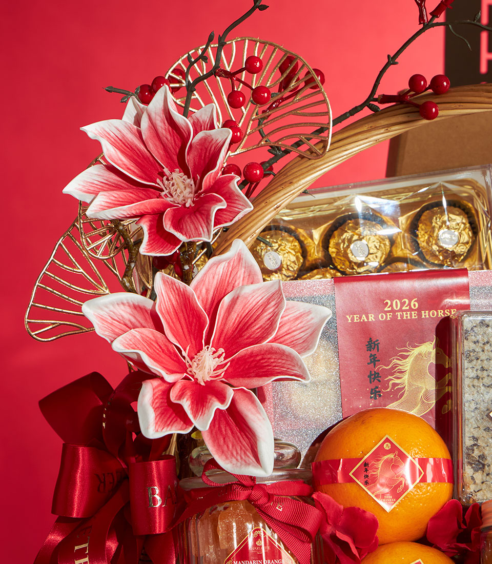 Luxury Chinese New Year gift basket with gold-wrapped chocolates, red silk flowers, fresh oranges, and festive horse-year