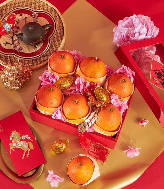 Premium mandarin orange gift box with golden ingots, red envelopes, and traditional teapot for Chinese New Year celebrations