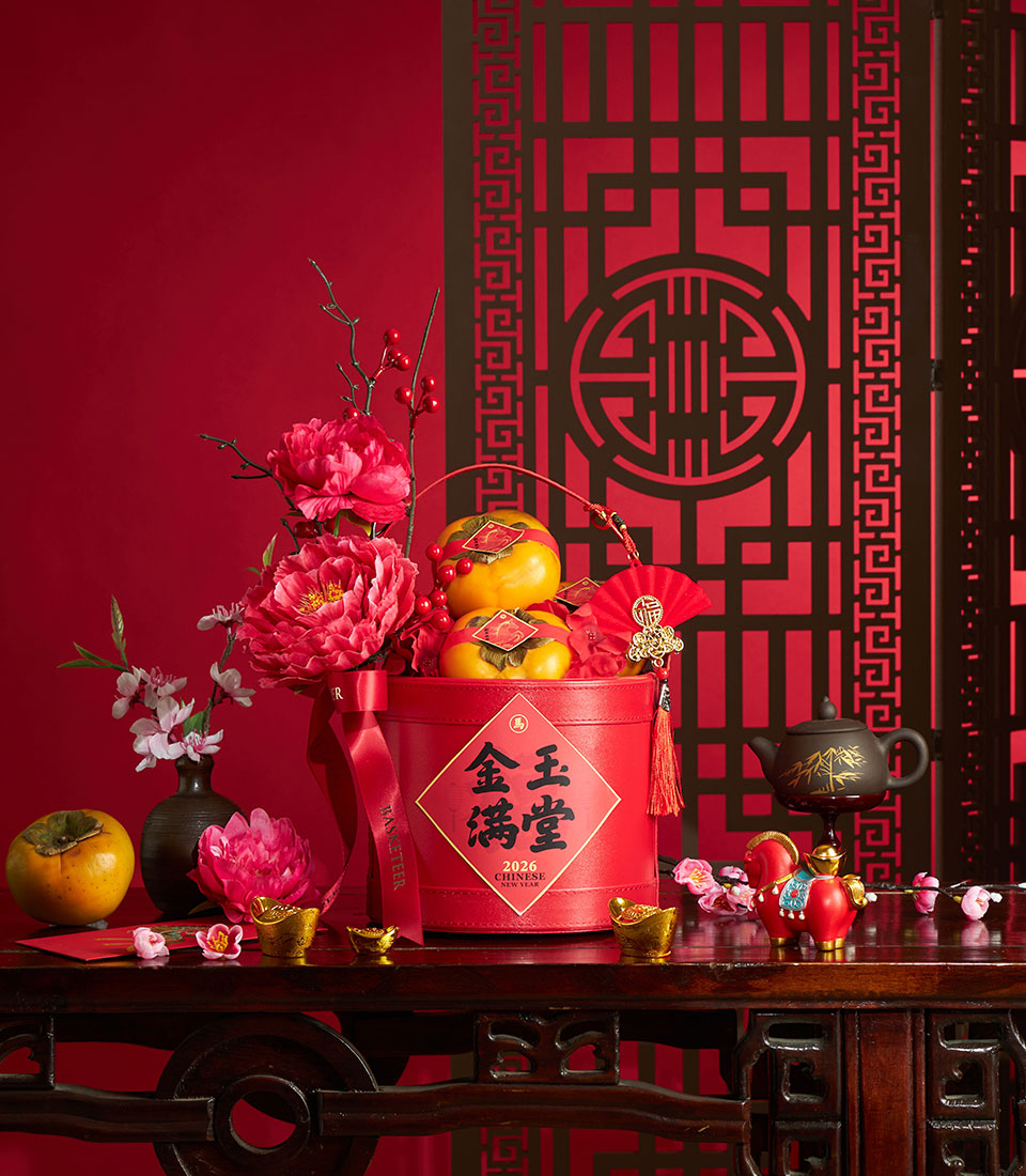 Red cylindrical gift box with persimmons, peonies, and lucky charms for Chinese New Year celebration