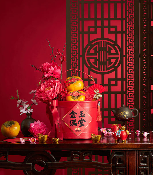 Red cylindrical gift box with persimmons, peonies, and lucky charms for Chinese New Year celebration