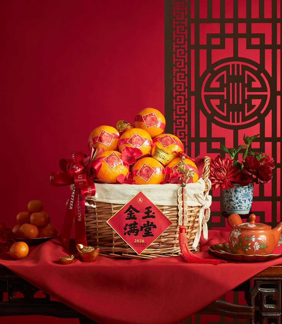 Festive wicker basket filled with red and gold dragon-wrapped mandarin oranges for Chinese New Year celebration