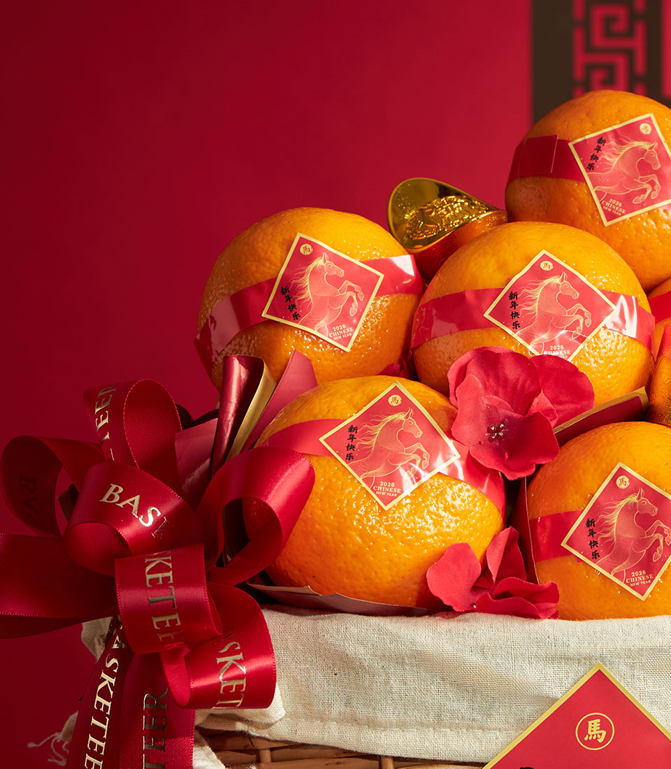Festive mandarin orange basket with red ribbons and gold ingot charms, classic woven design for Chinese New Year gifting