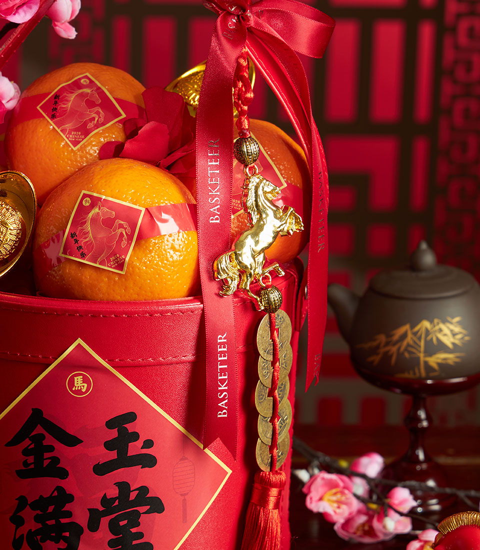 Festive Chinese New Year mandarin orange basket with red faux leather container, golden horse charm, and pink cherry blossom
