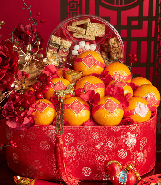 Red fabric gift box with mandarin oranges, golden horse charm, and festive sweets for Chinese New Year celebrations