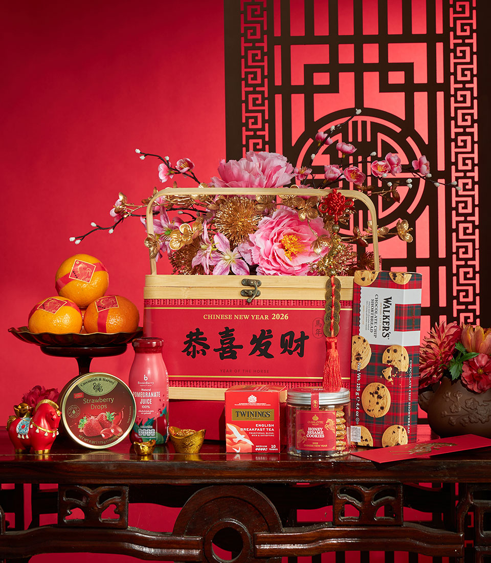 Luxury Chinese New Year gift hamper with mandarin oranges, artisan chocolates, premium tea, and festive decorations in red