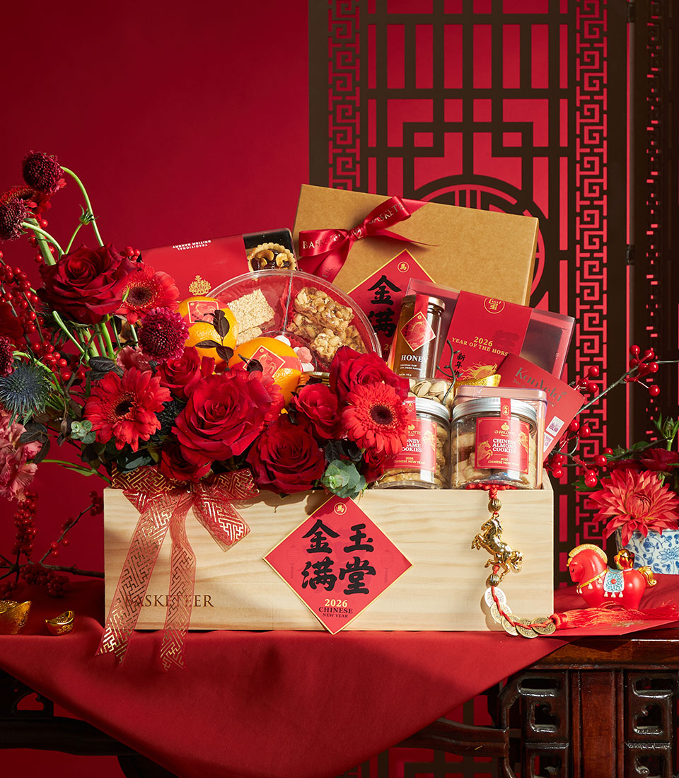 Luxury Chinese New Year gift basket with red roses, gerbera daisies, gourmet cookies, honey, and lucky charms in wooden crate