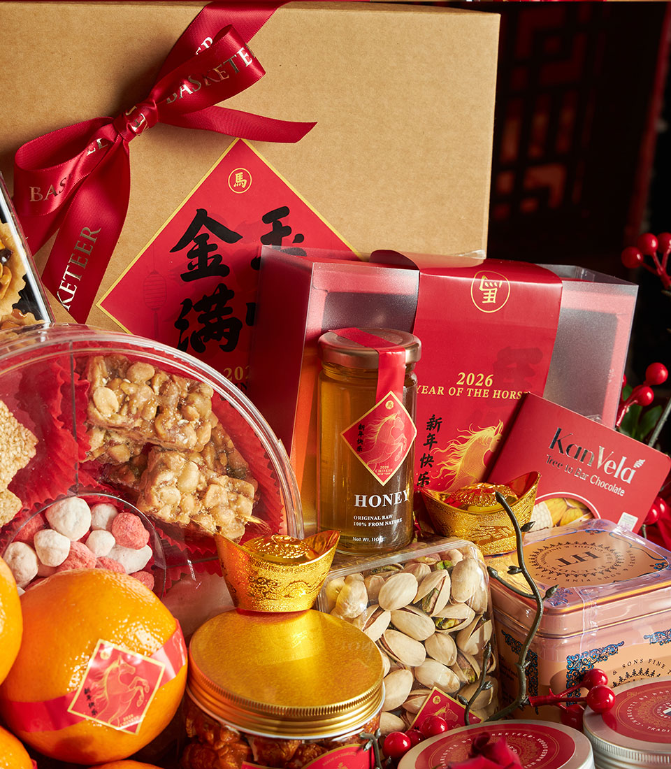 Luxury Chinese New Year gift hamper with mandarins, peanut brittle, honey, pistachios, and gold prosperity accents in red