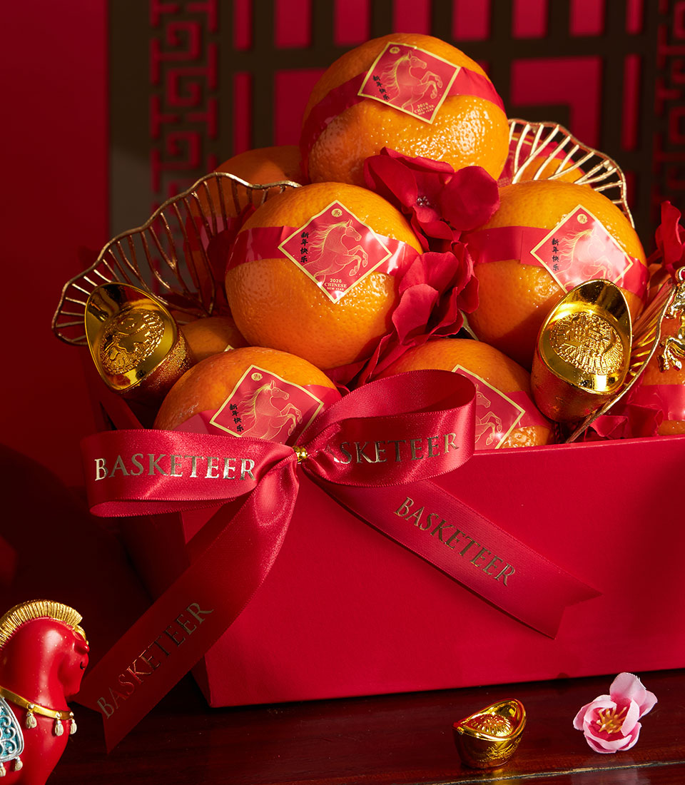 Festive Chinese New Year mandarin orange gift basket with red wrapping, gold ingots and lucky decorations