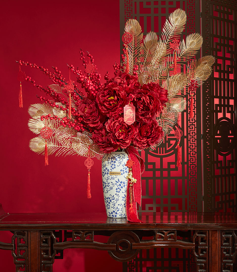 Deep red peony arrangement with gold peacock feathers and berries in blue-white ceramic vase, Chinese New Year gift