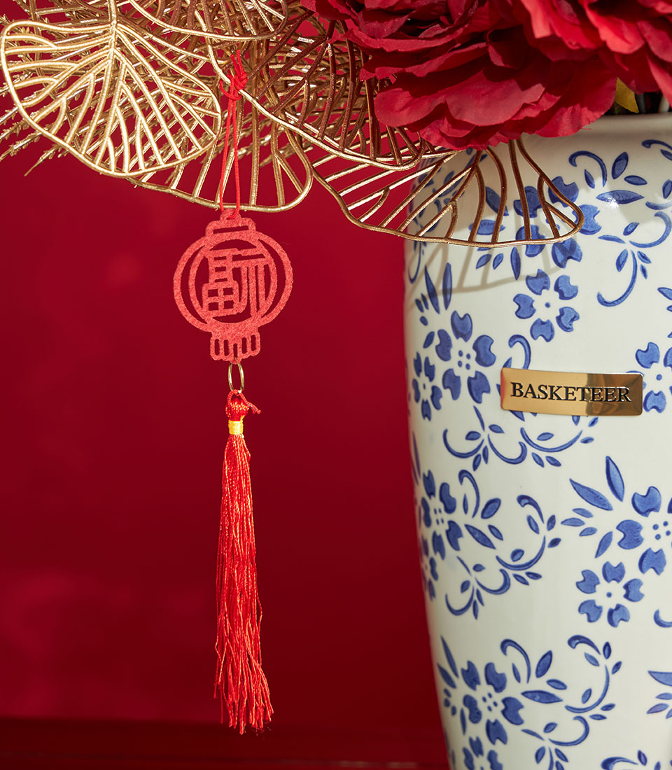 Red peony artificial flower arrangement with Chinese lantern ornament in blue and white porcelain vase