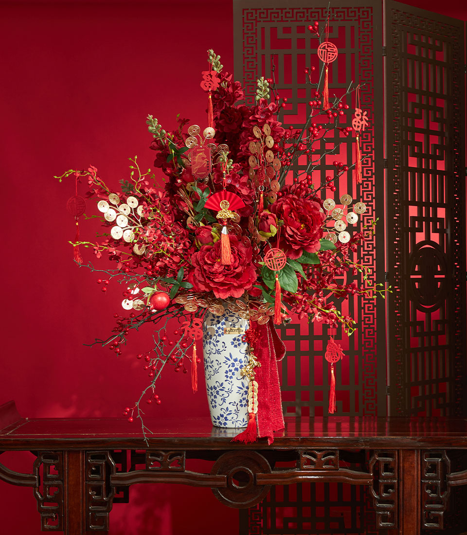 Basketeer premium hamper delivery Thailand: Vivid red peony arrangement with gold coin accents for Chinese New Year, a luxurious gift.