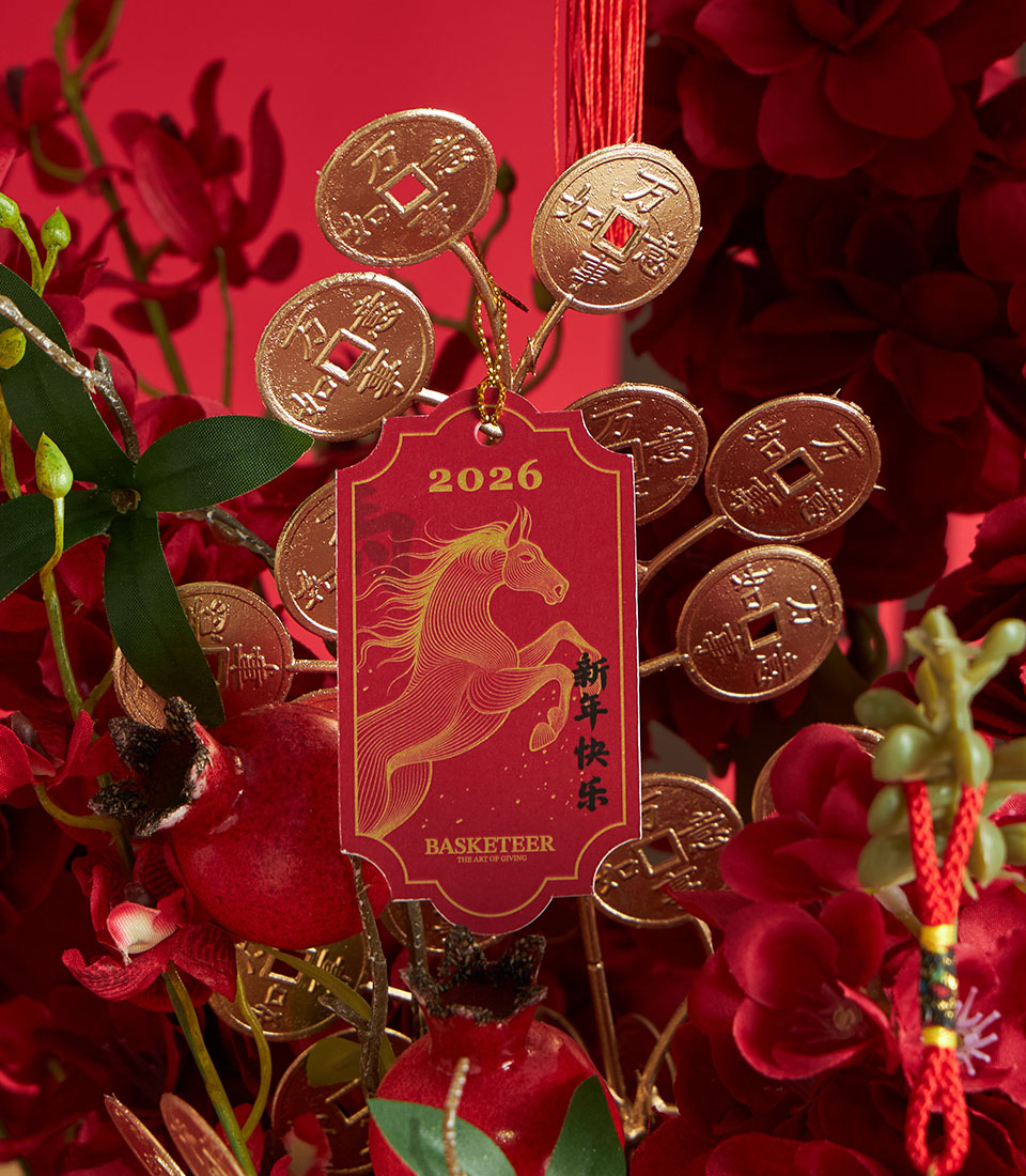 Basketeer premium hamper detail: Red peonies and gold coin accents create a luxurious Chinese New Year gift. Note the 2026 year of the horse tag.