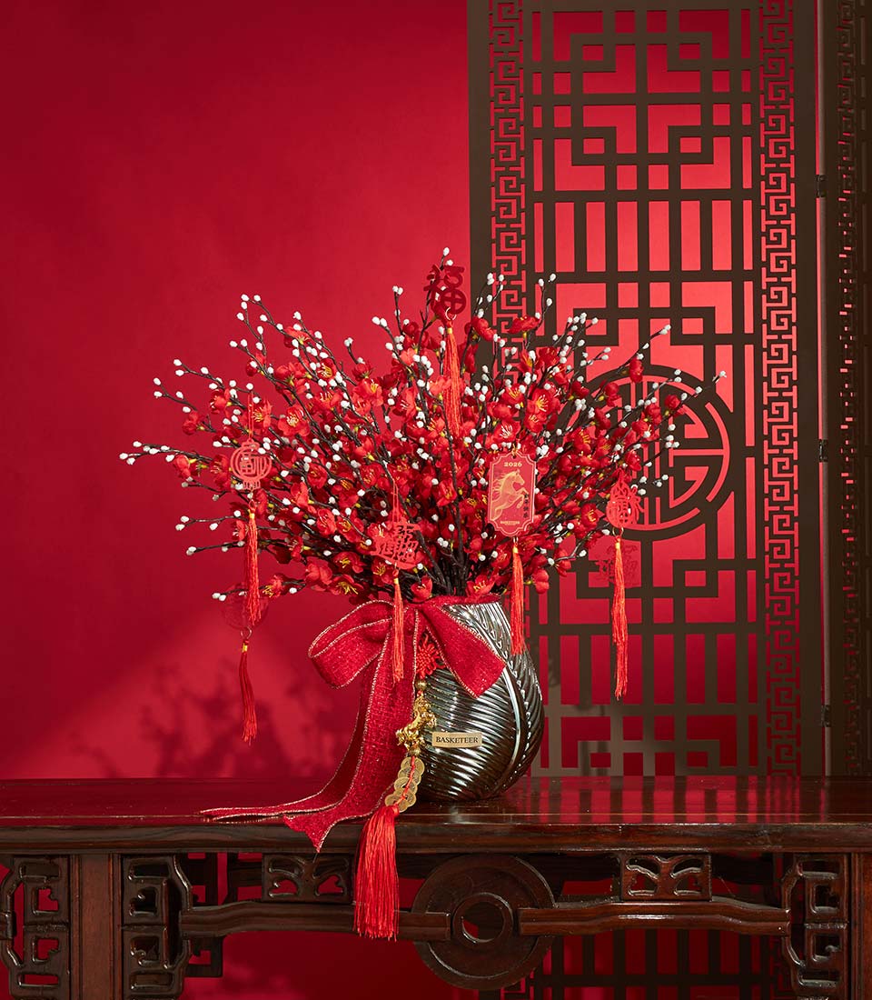Basketeer premium gift: A vibrant Chinese New Year arrangement of red cherry blossoms in a decorative vase, accented with a shimmering red ribbon. Perfect for same-day gift delivery in Bangkok.
