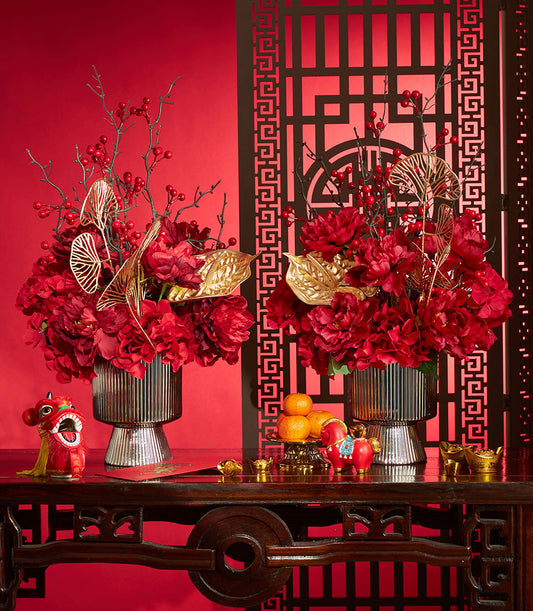 Basketeer luxury corporate gift: Red peony flower arrangements with gold accents, mandarin oranges, and traditional figurines for Chinese New Year in Bangkok.