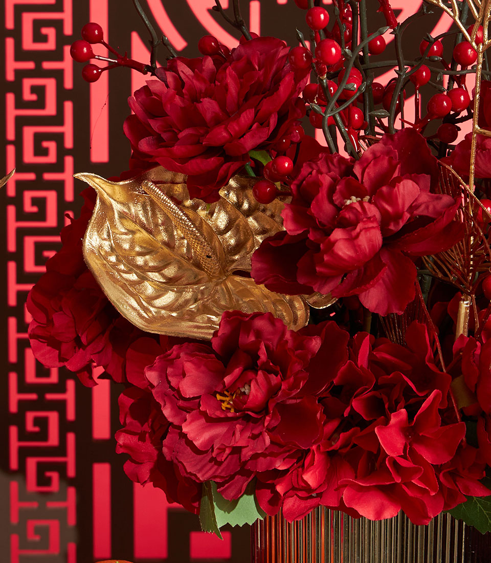 Basketeer luxury gift: Vibrant red flowers, golden leaves and berry accents create a festive Chinese New Year display for premium hamper delivery in Thailand.