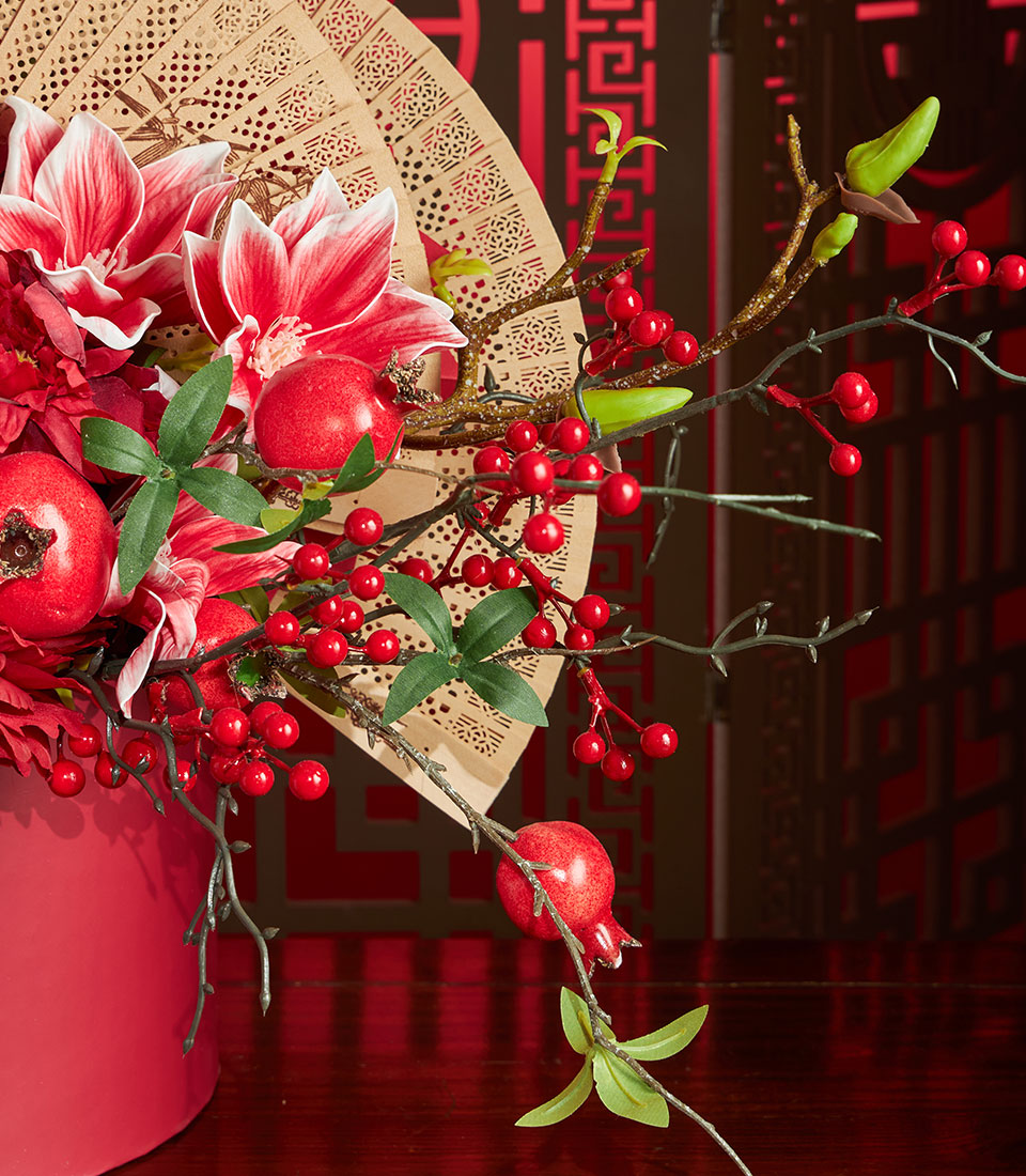 Basketeer's luxury Chinese New Year gift: a red floral arrangement with pomegranates, berries, and a decorative bamboo fan, for premium hamper delivery in Thailand.