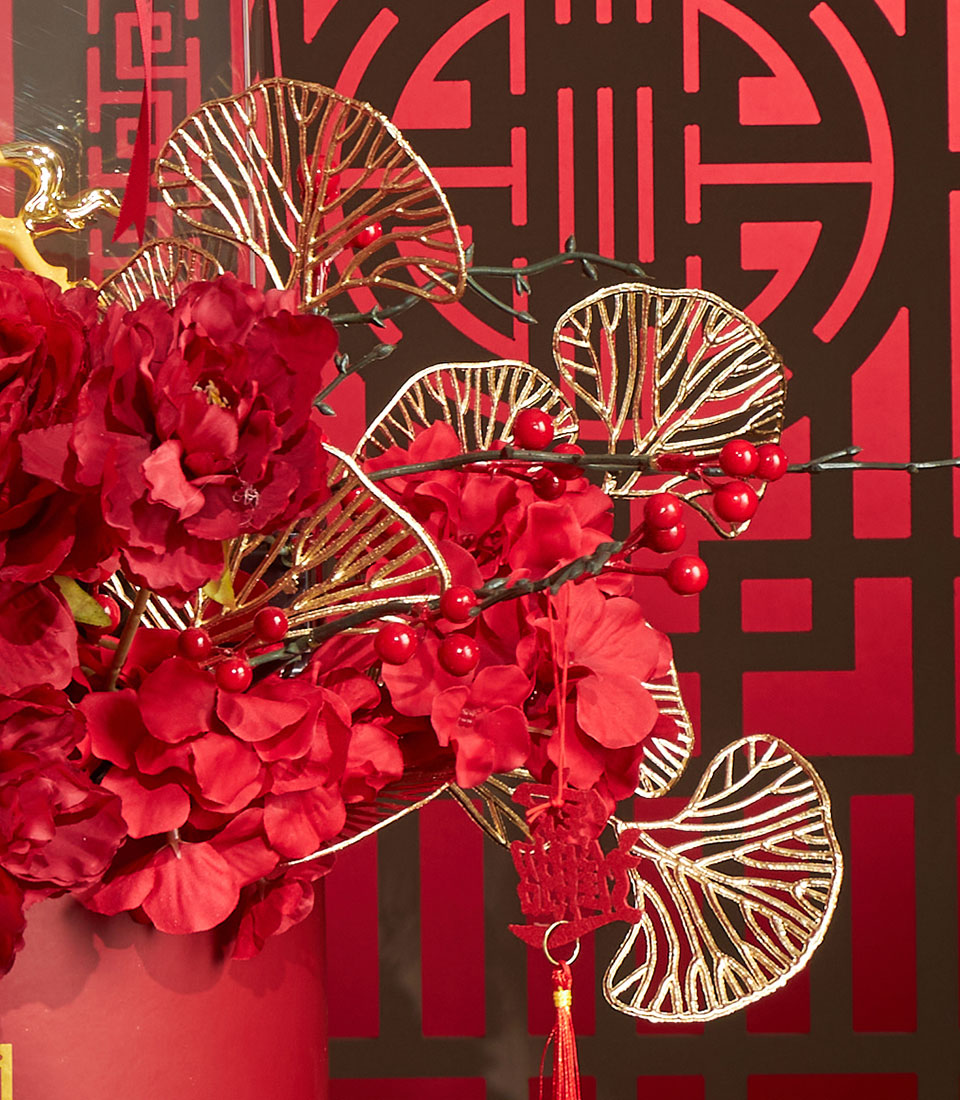 Red peonies and gold metallic leaves Chinese New Year floral arrangement with lucky charm tassel