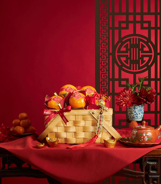 Classic wooden basket with red-wrapped mandarin oranges, gold accents, and Chinese New Year festive styling for luxury