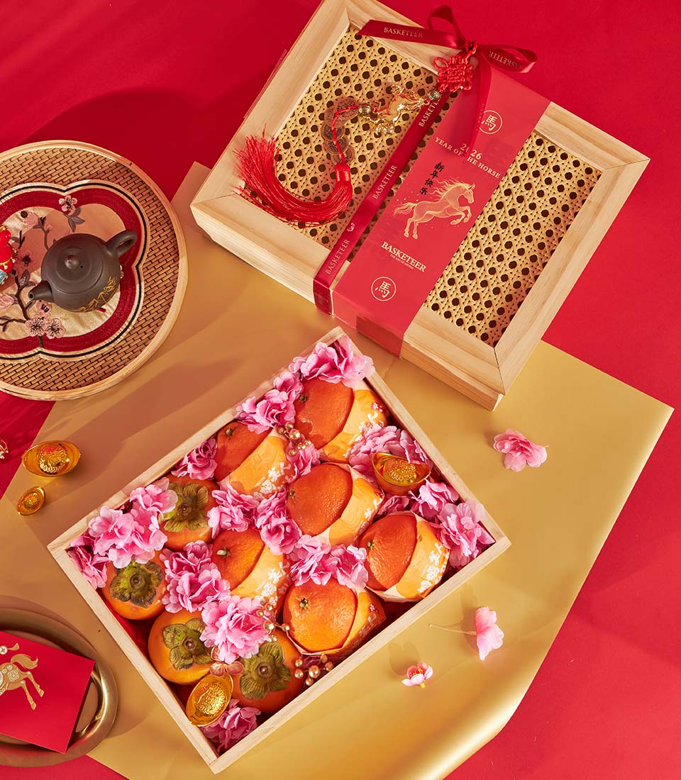 Premium fruit gift box with persimmons, tangerines, and gold accents for Chinese New Year celebrations