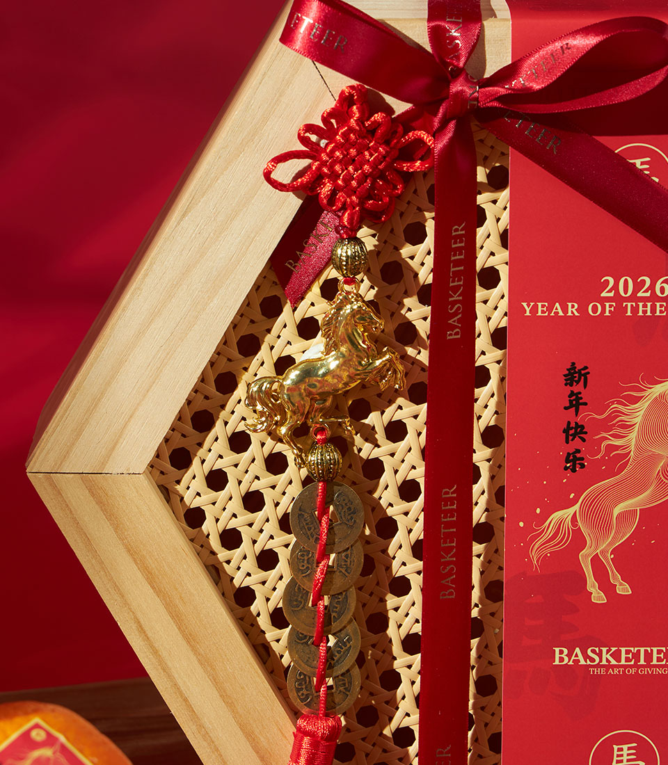 Premium red and gold Chinese New Year gift box with mandarin oranges, festive sweets, and golden horse charm