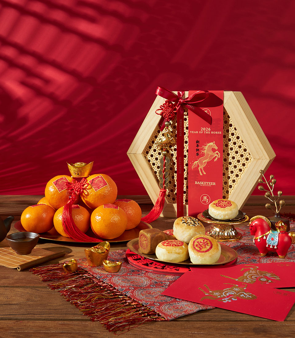 Premium Chinese New Year gift set with mandarin oranges, artisan pastries, and lucky charms in hexagonal wooden basket