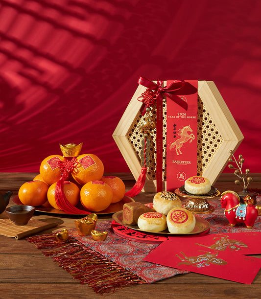 Premium Chinese New Year gift set with mandarin oranges, artisan pastries, and lucky charms in hexagonal wooden basket