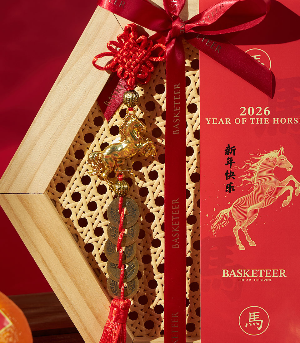 Red Chinese New Year gift box with mandarin oranges and pastries, gold horse charm and lucky coins for Year of the Horse 2026
