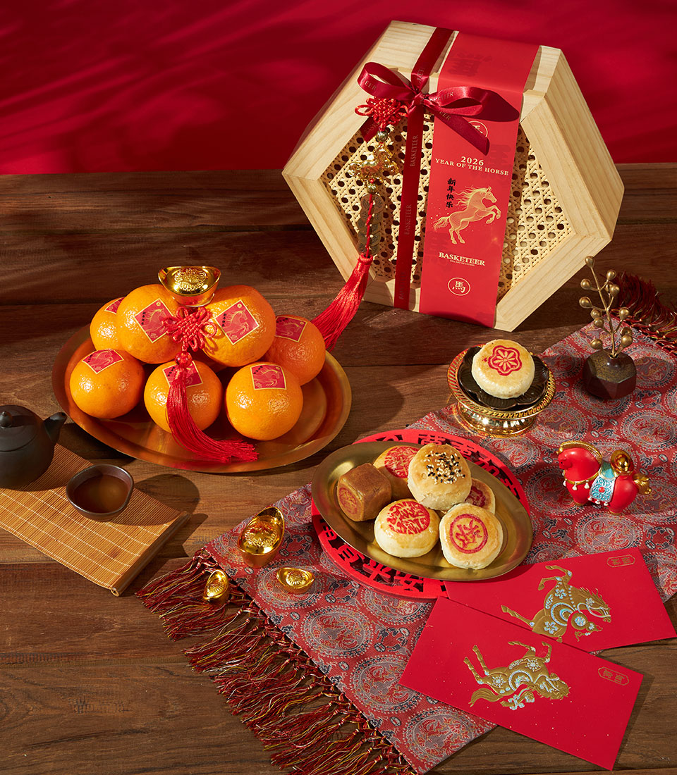 Festive Chinese New Year hamper with mandarin oranges, artisan pastries, and lucky gold ingots in rattan-trimmed wooden box