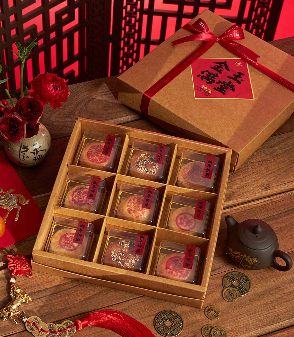 Luxury Chinese New Year gourmet gift basket with nine artisan pastries, ceramic vase, and traditional tea set on wooden