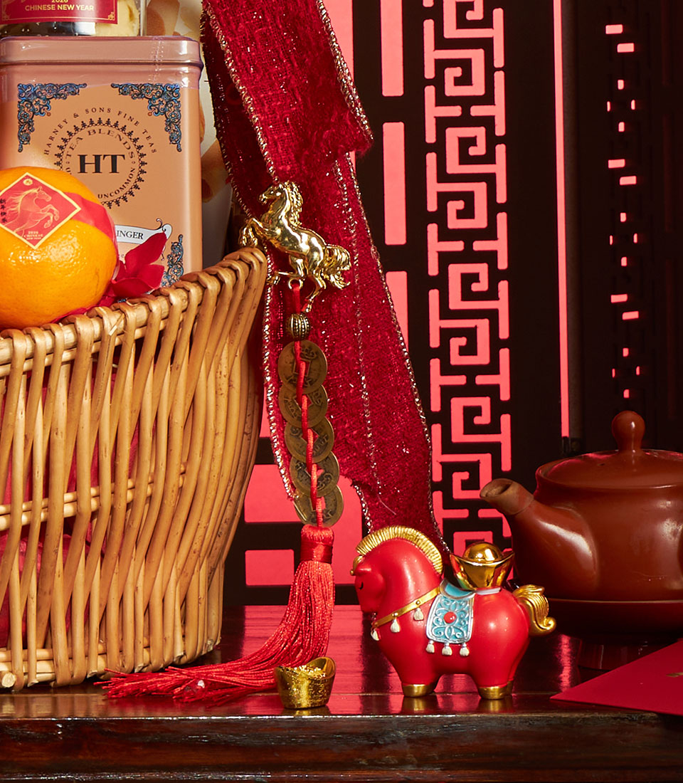 Abundance Chinese New Year gift basket with mandarin orange, tea tin, red ribbon, gold horse charm, and traditional