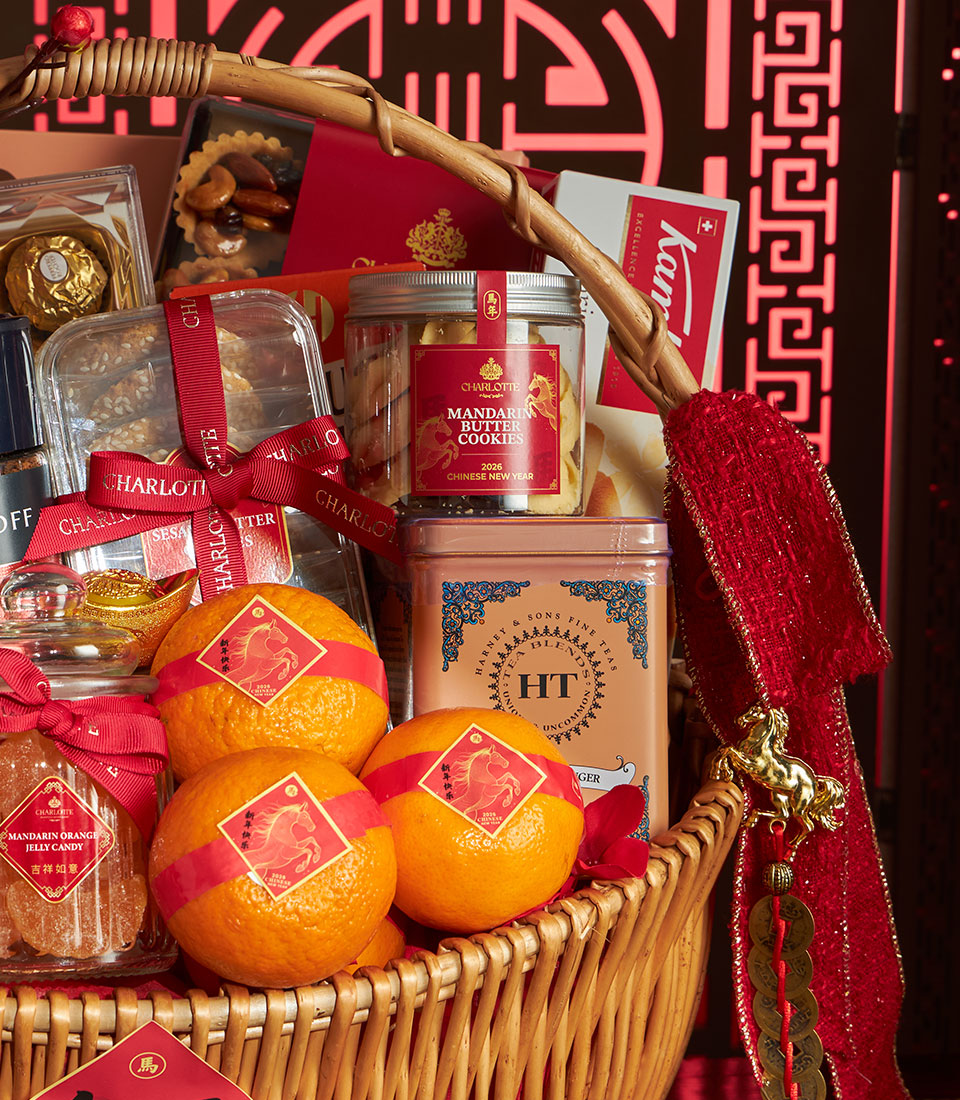 Woven luxury gift basket with mandarin oranges, gourmet cookies, artisan teas, and festive red ribbons for Chinese New Year