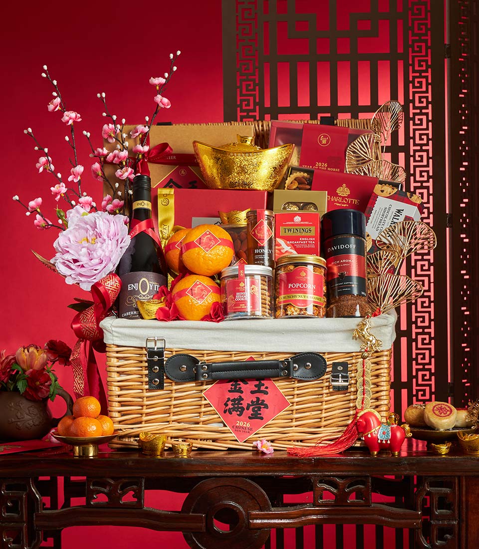 Premium wicker gift hamper with red wine, gourmet treats, gold ingots, and cherry blossoms for Chinese New Year