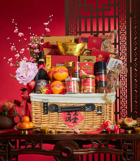 Premium wicker gift hamper with red wine, gourmet treats, gold ingots, and cherry blossoms for Chinese New Year