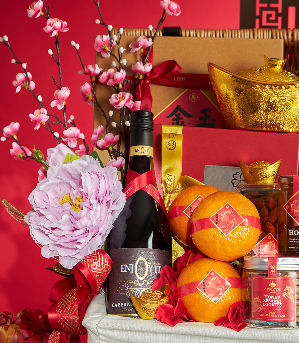 Premium Chinese New Year gift hamper with non-alcoholic wine, mandarins, honey sesame cookies, and golden accents in woven
