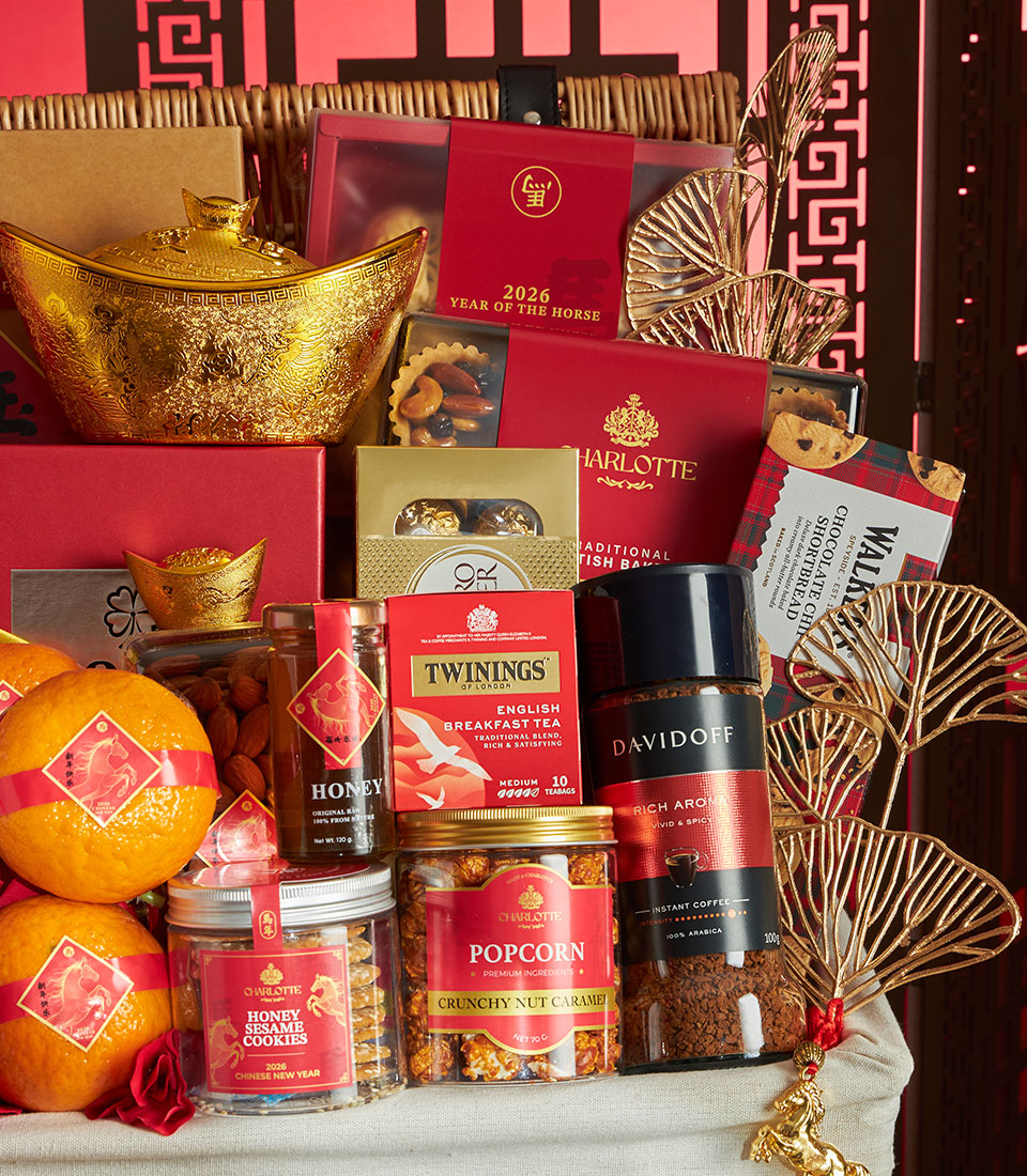 Luxury red and gold Chinese New Year gift hamper with gourmet treats, fresh oranges, and artisan snacks in woven basket
