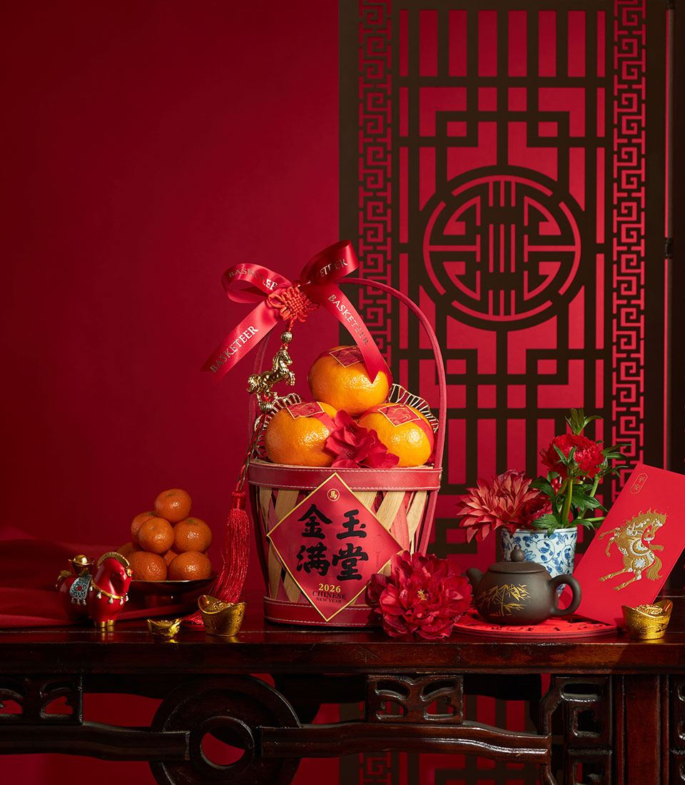 Festive Chinese New Year mandarin orange basket with red ribbon and gold horse charm on dark wood
