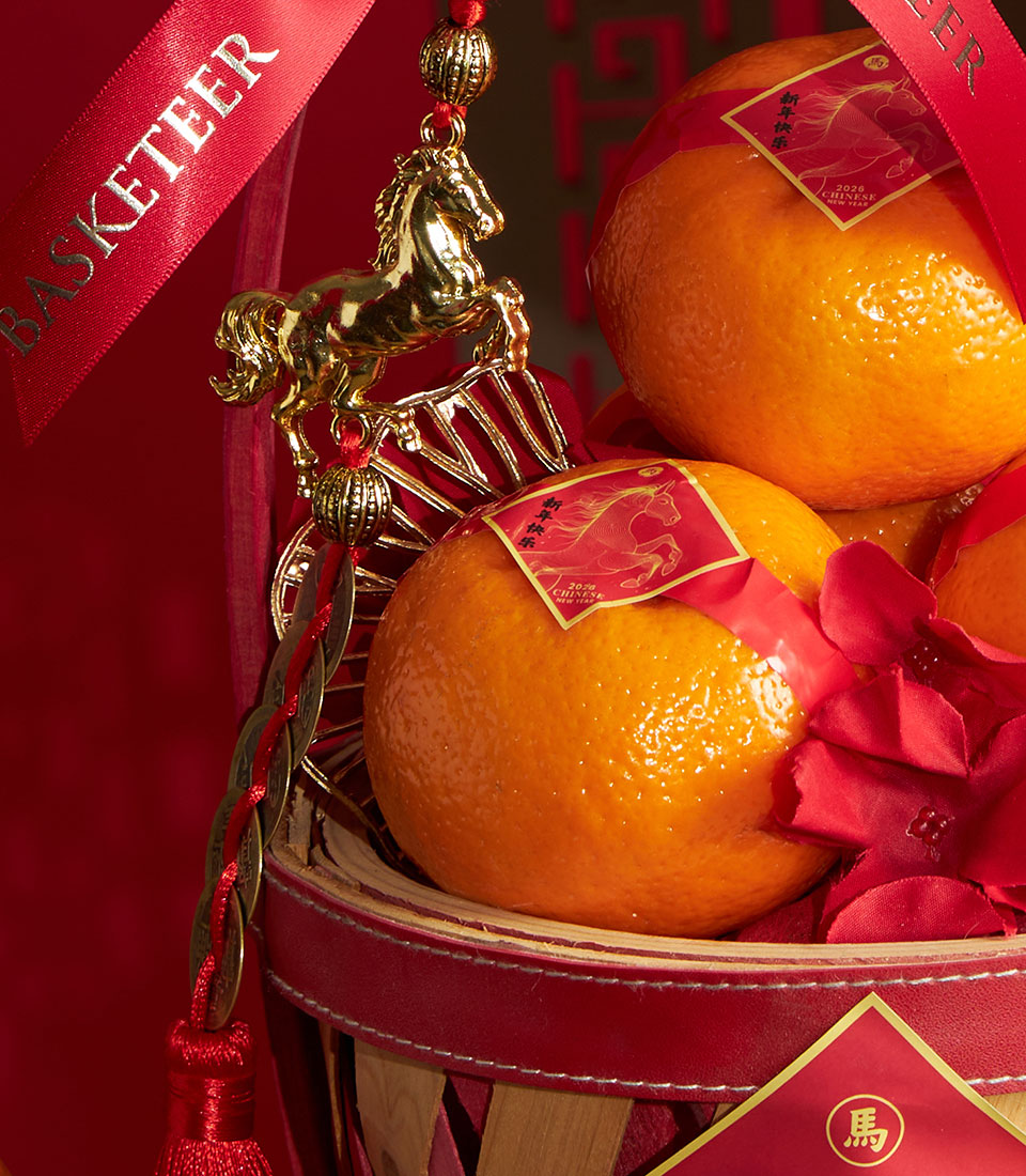 Festive Chinese New Year mandarin orange gift basket with red ribbons, golden horse charm, and lucky coins