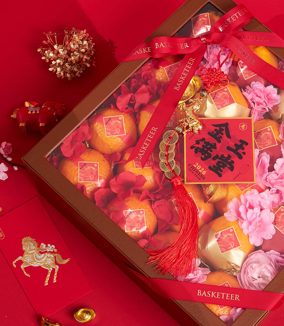 Premium mandarin orange gift box with gold foil wrapping, red flowers, and lucky charms for Chinese New Year