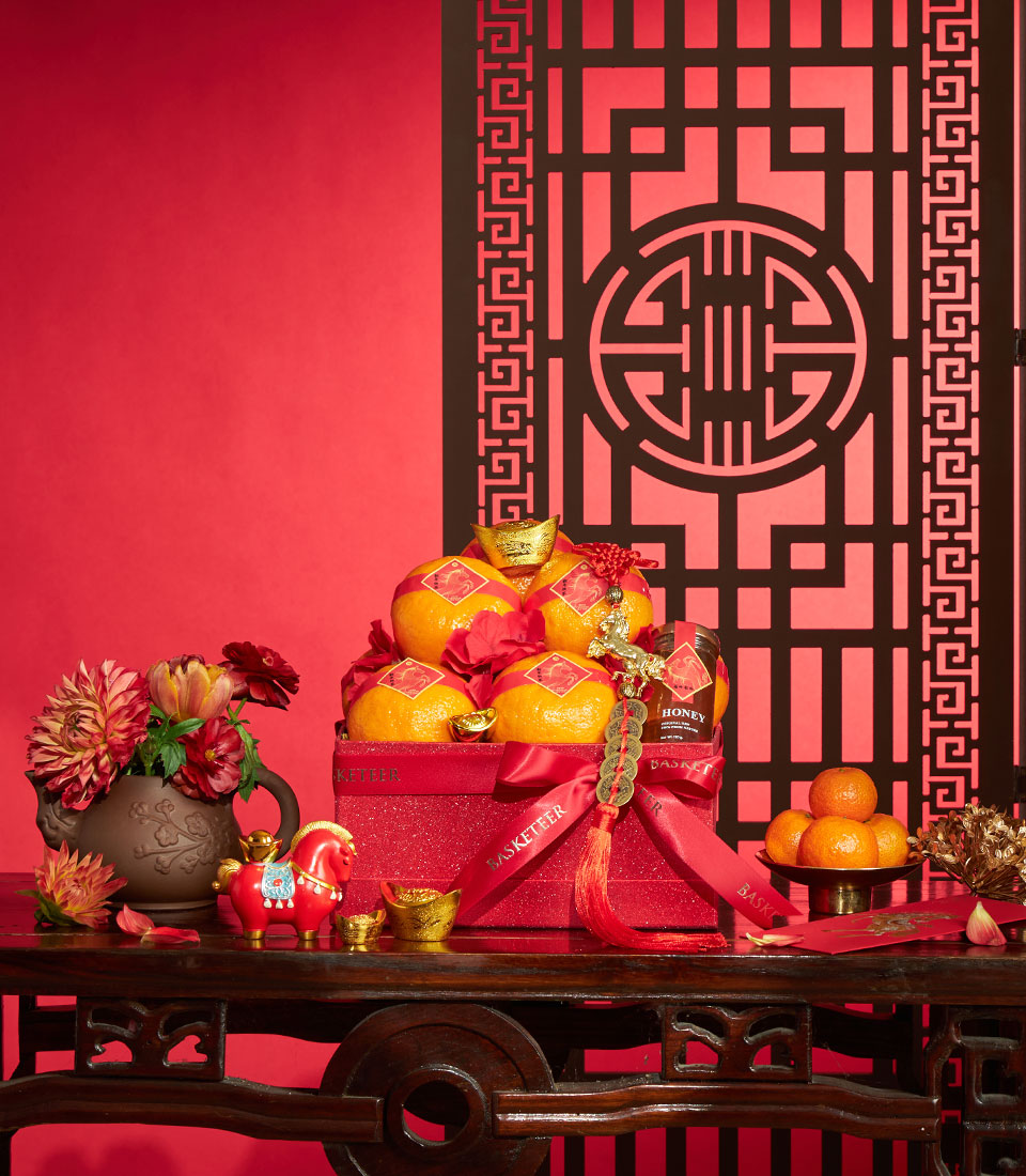 Premium mandarin oranges with Charlotte honey in red luxury Chinese New Year gift box, gold accents and festive red flowers