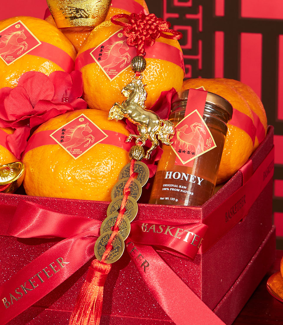 Premium mandarin oranges and Charlotte honey in festive red Chinese New Year gift box with golden horse charm