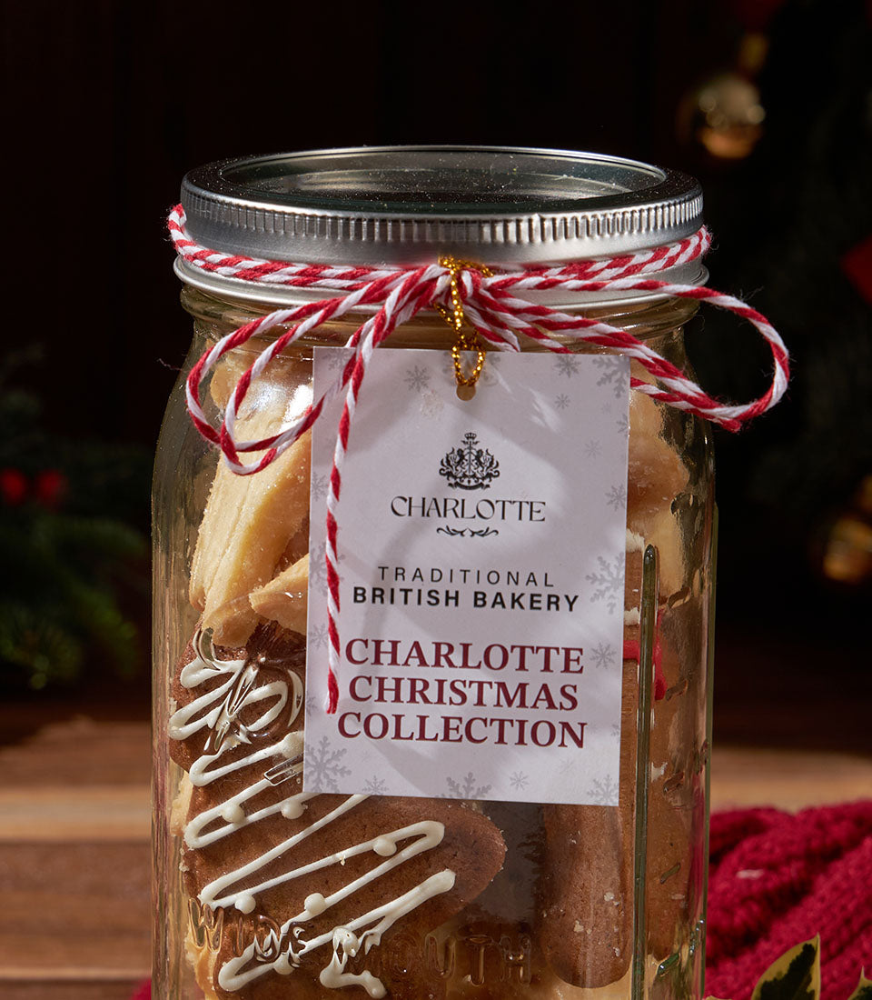 Charlotte Bakery Christmas shortbread cookies in a mason jar, tied with baker's twine. Some are drizzled with white icing. British bakery Thailand.