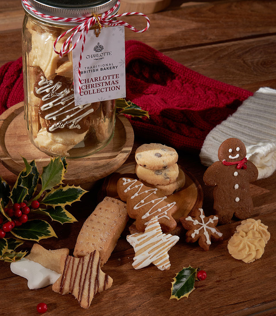 Festive Christmas shortbread and ginger cookies in ribbon-tied glass jar with holly and red knitted accents
