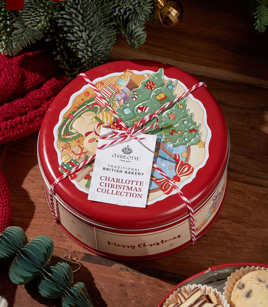 Festive red tin of traditional British Christmas biscuits with holiday illustration and gift tag on wooden surface