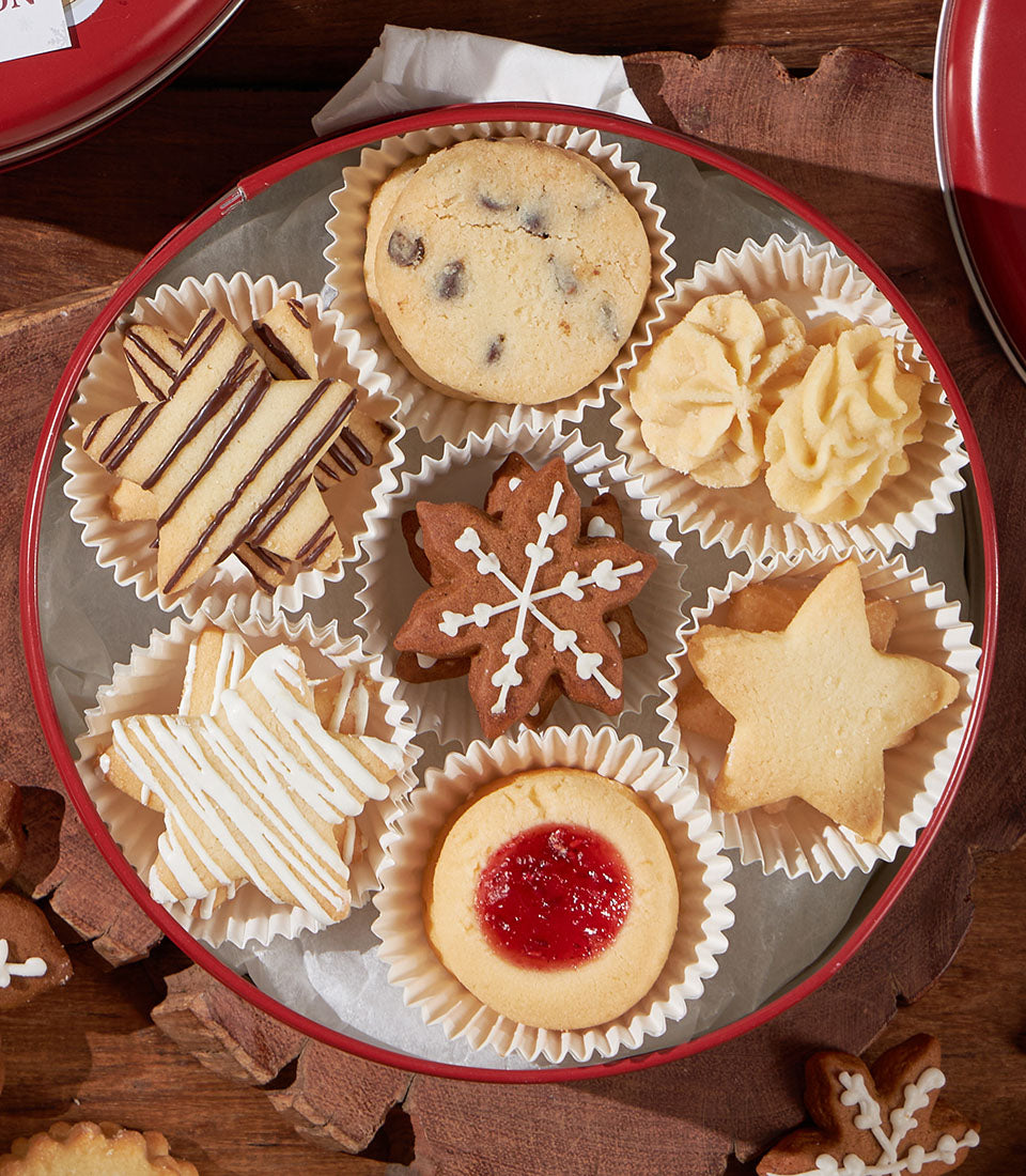 Christmas biscuit assortment in red tin with chocolate chip, shortbread, gingerbread, and jam-filled cookies